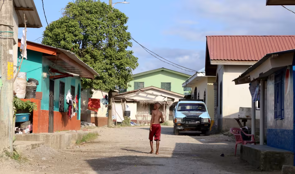 A boy walks through a coastal village in Honduras.
