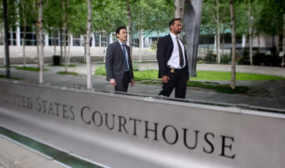 U.S. immigration officials walk by a courthouse in Seattle.