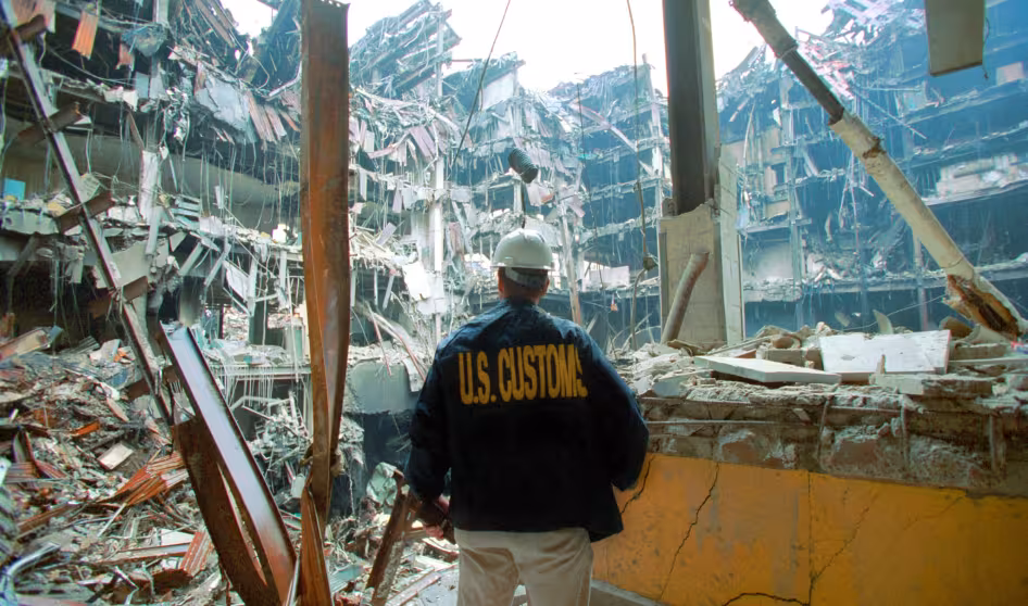 A U.S. Customs agent looks at wreckage following the 9/11 terror attacks