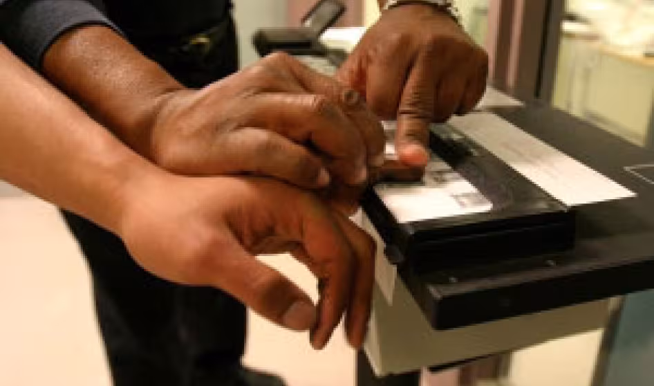 An officer in the Harris County (TX) Sheriff's Office takes the fingerprints of an individual it arrested. Harris County has a 287(g) agreement with ICE.