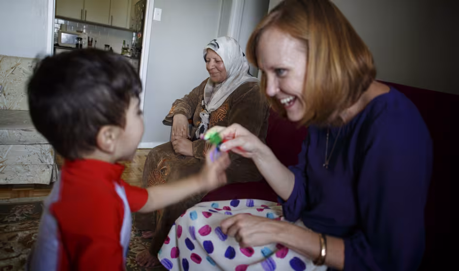 A private refugee sponsor in Canada plays with a boy.