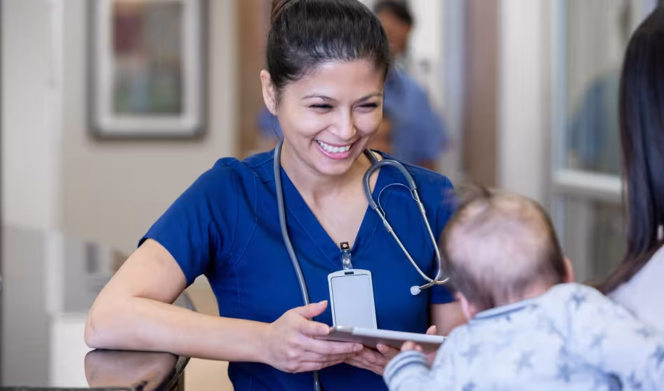 A nurse looks at a baby.