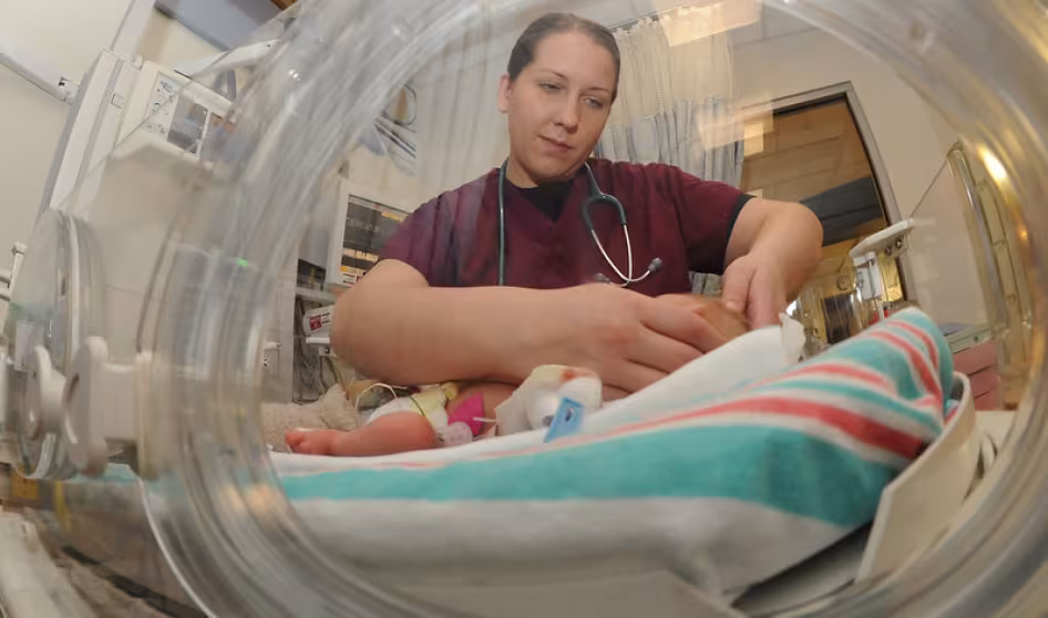 An intern examines a newborn baby in the Neonatal Intensive Care Unit.