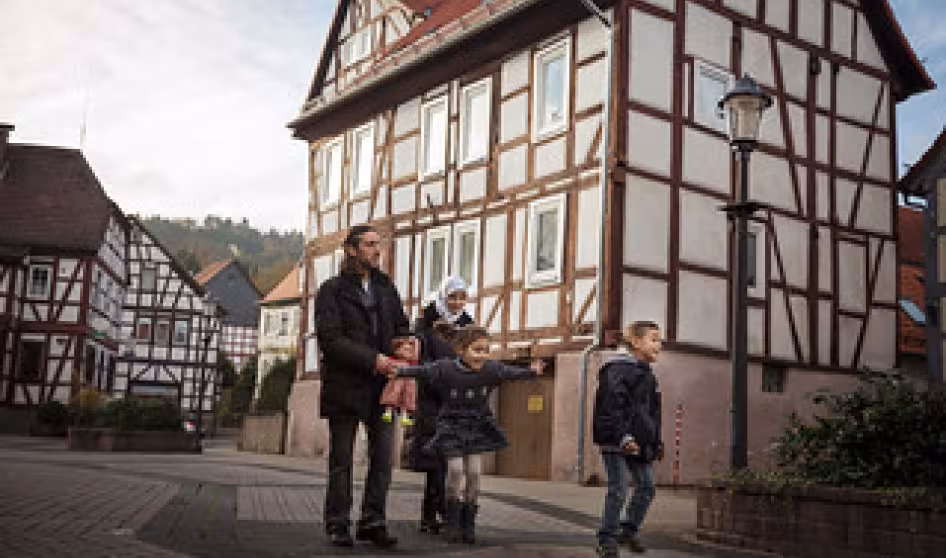 A family from Syria walks through the town of W&auml;chtersbach, Germany, where they now live.