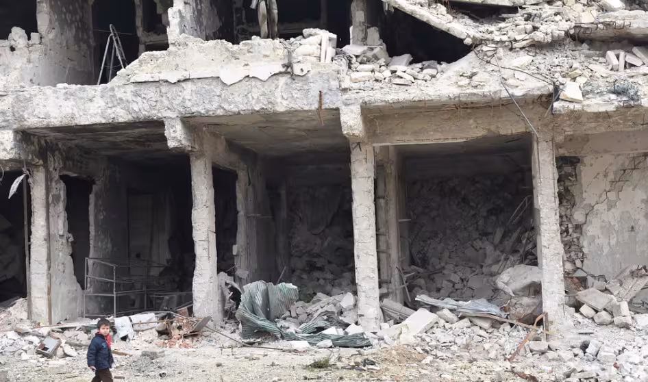 A child walks by a destroyed building in Syria. 