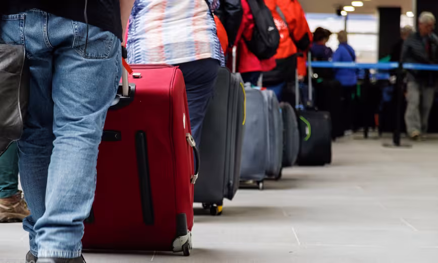 A line of people with suitcases