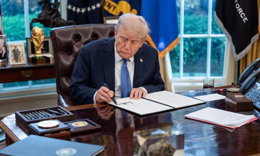 President Donald Trump signs a bill in the Oval Office