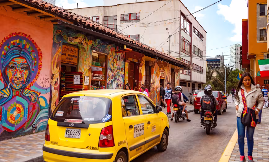 People and traffic in a colorful street in Bogot&aacute;, Colombia
