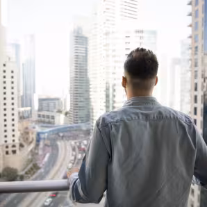 The back of a man looking out at a city
