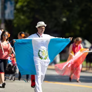 A man carrying the flag of Guatemala in a parade in Washington, DC.