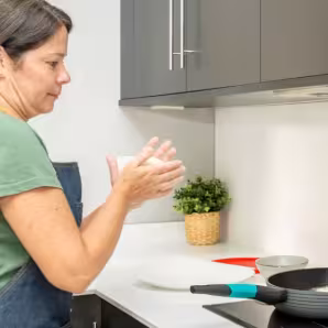 A woman makes arepas in the kitchen.