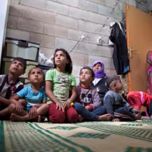 Children and women gaze off in a house