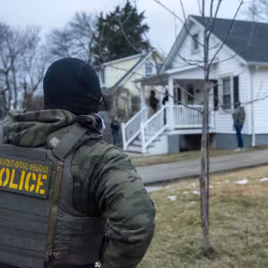 An ICE officer outside a home in Baltimore, Maryland.