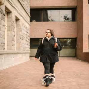 Photo of woman walking around a school campus.