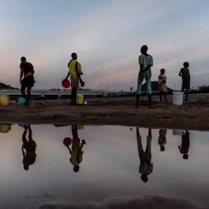 Photo of a group of women collecting water from a riverbed in Kenya