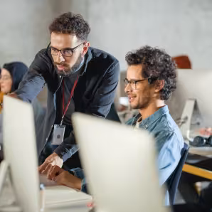 Image of teacher helping group of students at their computers