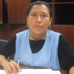 Woman in blue smock sitting at table