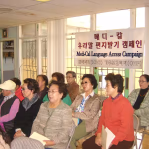A group of older Korean adults sitting in chairs at a Med-Cal event at the Korean Resource Center