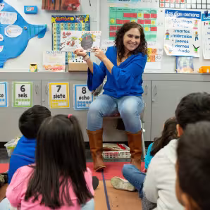 Photo of a preschool teacher reading to students.