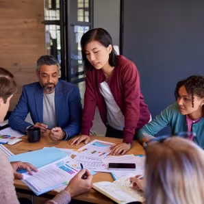 Male and female business professionals gathered at a conference table