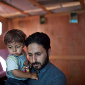 Syrian father holds his young son in Lebanon