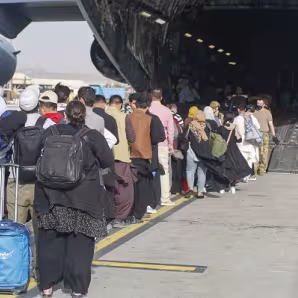 Evacuees prepare to board a C-17 at Hamid Karzai International Airport, Afghanistan