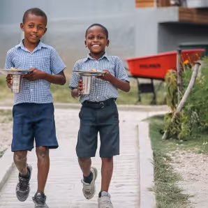 Haitian school children walking down a sidewalk