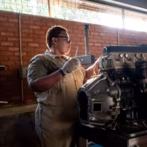 Migrant working on repairing or building an engine