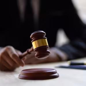 Hand holding a judge's gavel