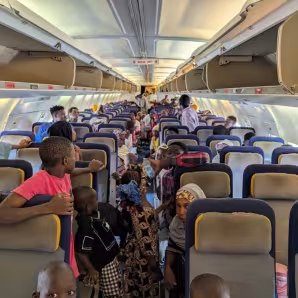 Returning migrants sitting on airplane