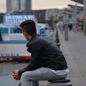 A refugee looks out over Hamburg harbor