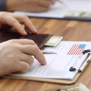 Man fills out immigration paperwork on a clipboard
