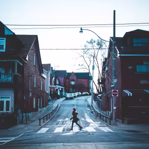 Woman walks across a street in a Toronto neighborhood