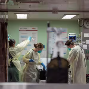 Three health professionals wearing masks in a hospital