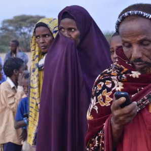 A refugee texts while waiting to register at Ifo refugee camp in Dadaab, Kenya.