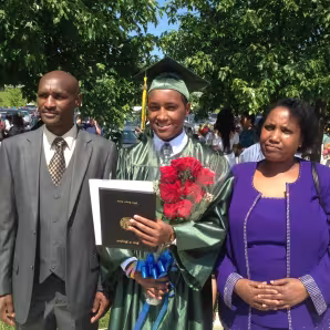 A refugee student with his family at graduation.