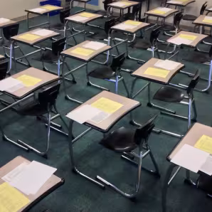 A classroom with exam papers on students' desks