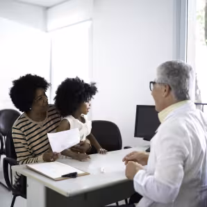 Mother and daughter sitting at a desk for an appointment