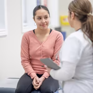 Latina teenager in medical office with clinician