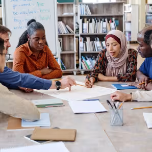 Adult immigrant students work together in an English class