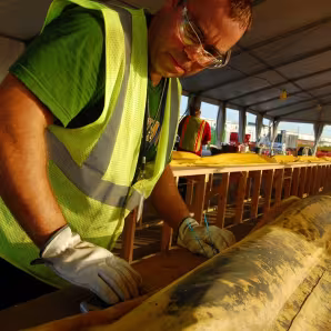 A man in a high-visibility jacket and gloves at work