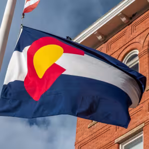 Colorado flag in front of a brick building