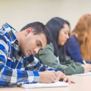 A multiethnic classroom of university students sit at their desks
