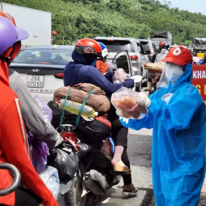 Volunteer hands out food to migrant workers returning to their hometowns in Vietnam