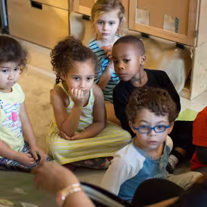 A group of preschoolers listen to a story