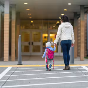 A mother and toddler walking into a school