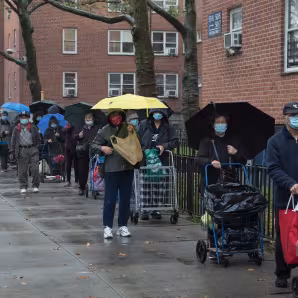A crowd of people outside a food pantry