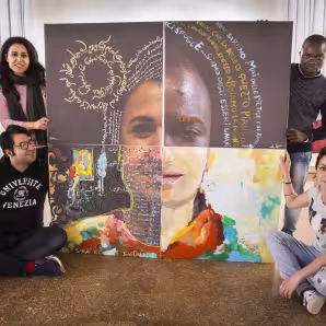 Four refugee artists stand with art they have created that will be shown at the Venice Biennale