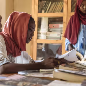Two women at a Sudanese community center rehabilitated by IOM and a local NGO