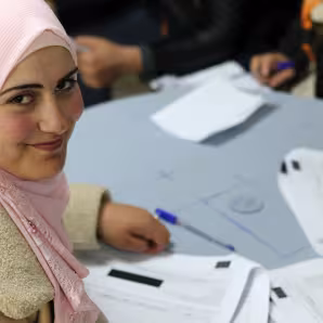 A woman in Amman smiles after completing a form